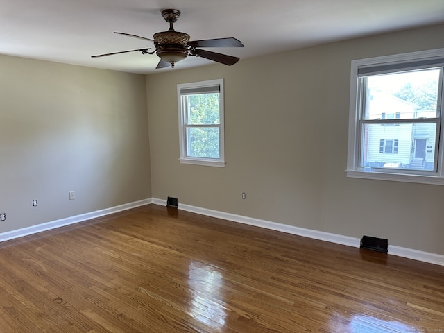 unfurnished room featuring hardwood / wood-style flooring, ceiling fan, and plenty of natural light