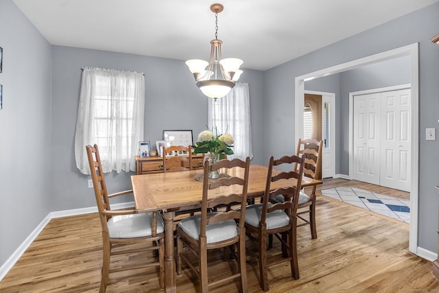 dining space featuring an inviting chandelier and light hardwood / wood-style floors