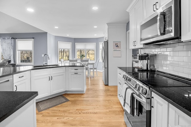 kitchen with sink, plenty of natural light, stainless steel appliances, and white cabinets