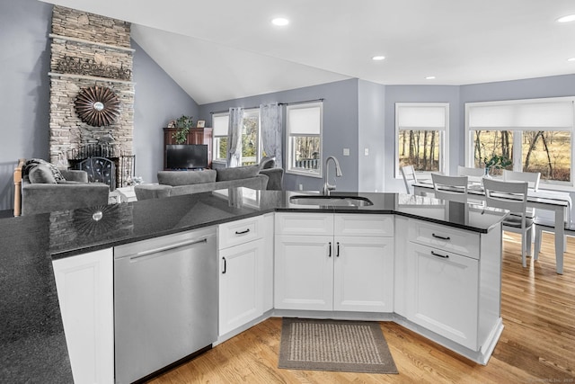 kitchen with white cabinetry, dishwasher, sink, and dark stone countertops