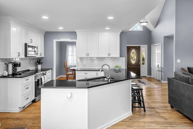 kitchen with white cabinetry, sink, stainless steel appliances, and a center island