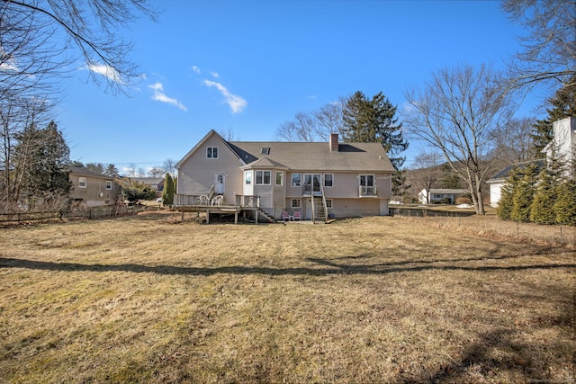 back of property featuring a lawn and a deck