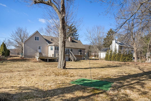 rear view of house with a yard and a deck