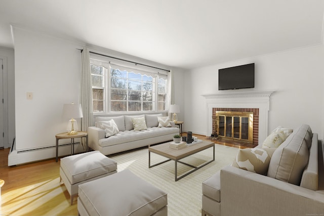 living room featuring a baseboard radiator, a brick fireplace, ornamental molding, and hardwood / wood-style floors