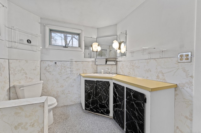 bathroom with vanity, toilet, and tile walls