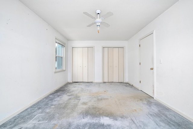 unfurnished bedroom featuring two closets and ceiling fan