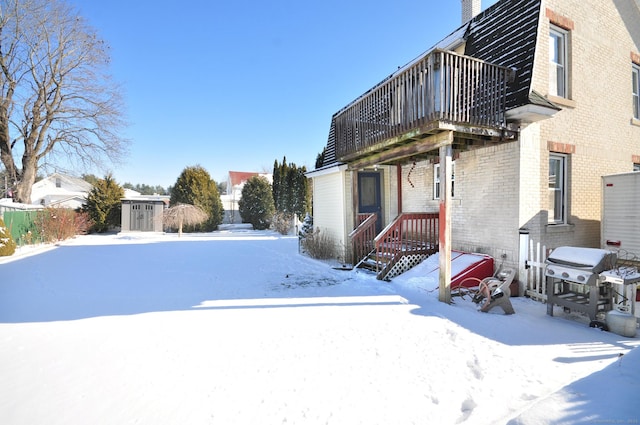 yard layered in snow with a shed