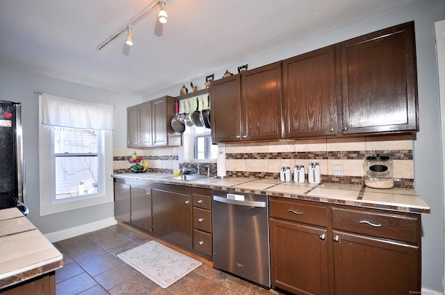 kitchen with sink, backsplash, dark brown cabinets, stainless steel appliances, and tile countertops