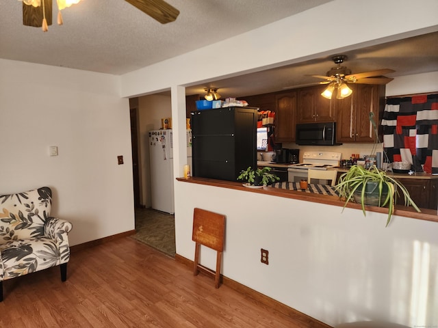 kitchen with ceiling fan, white appliances, dark brown cabinetry, and kitchen peninsula