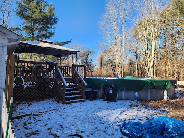 snowy yard featuring a gazebo and a pool side deck