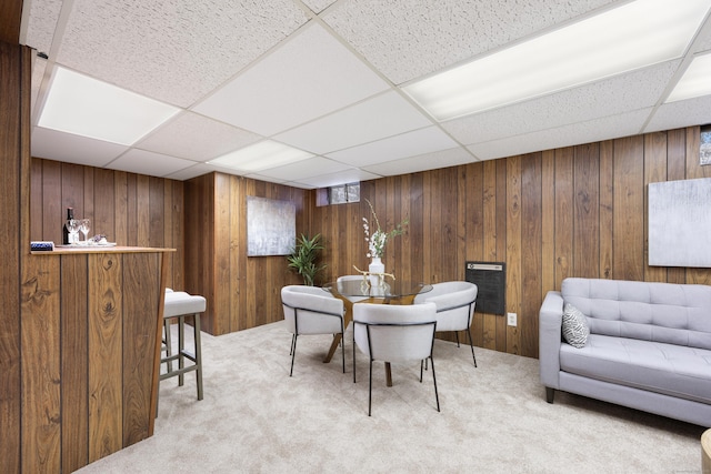 interior space with wooden walls and a drop ceiling