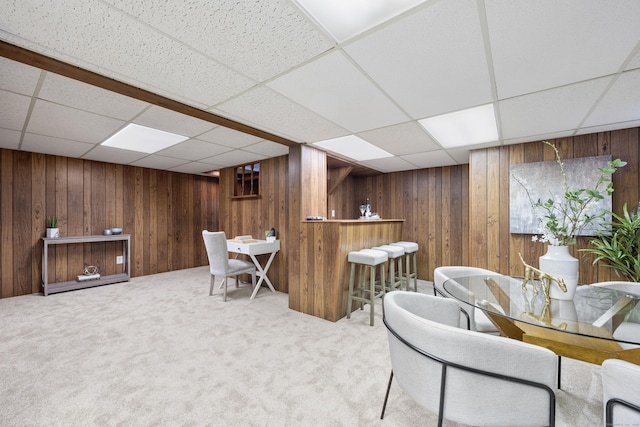 interior space with a paneled ceiling and light colored carpet