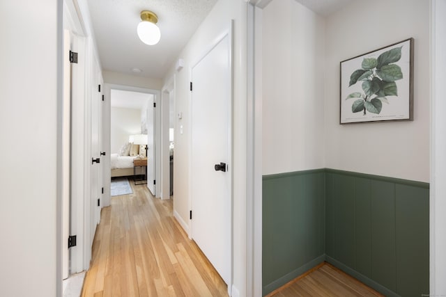 corridor with hardwood / wood-style floors and a textured ceiling