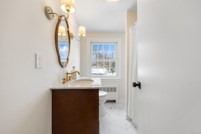 bathroom featuring vanity, toilet, radiator, and a textured ceiling