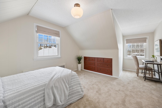 bedroom with a textured ceiling, light colored carpet, and vaulted ceiling