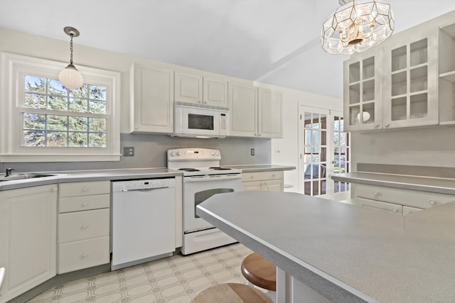 kitchen featuring decorative light fixtures, sink, white cabinetry, and white appliances