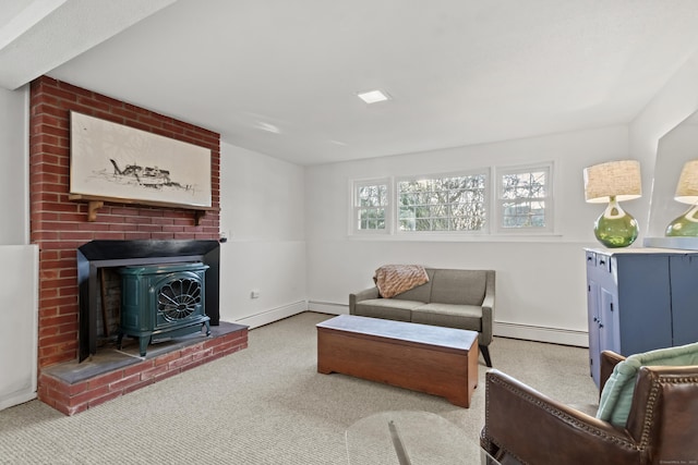 living room featuring baseboard heating, carpet, and a wood stove