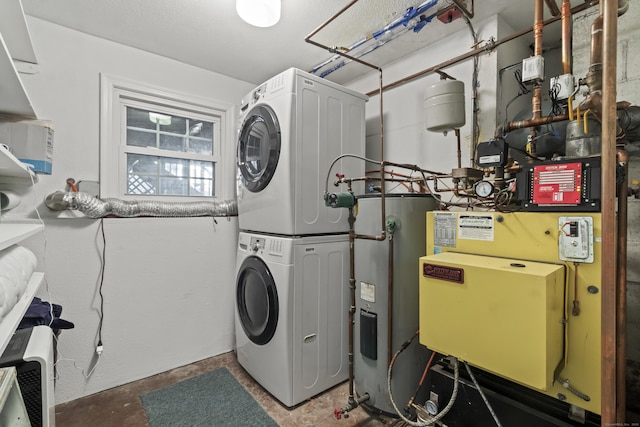 clothes washing area featuring stacked washer / dryer and water heater