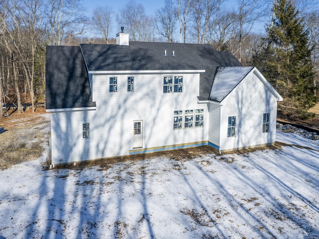 view of snow covered back of property