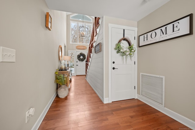 foyer entrance featuring hardwood / wood-style flooring and a notable chandelier