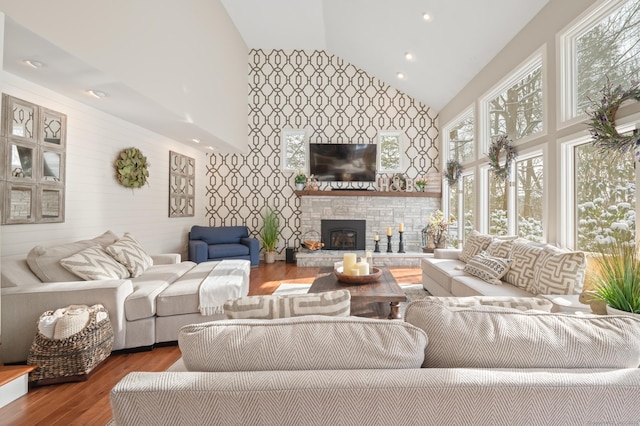 living room featuring a fireplace, wood-type flooring, and high vaulted ceiling