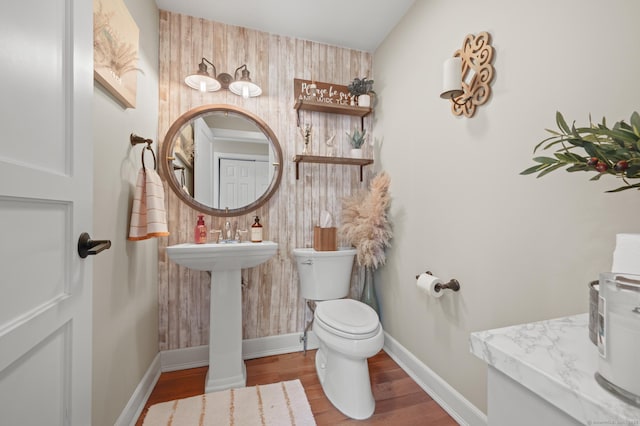 bathroom with wood-type flooring, toilet, and sink