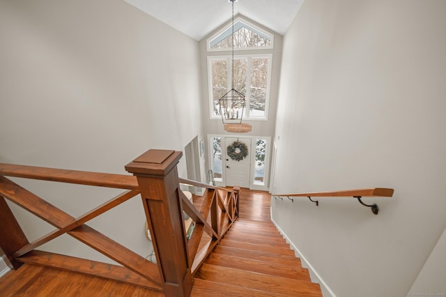 stairway featuring hardwood / wood-style flooring and a chandelier