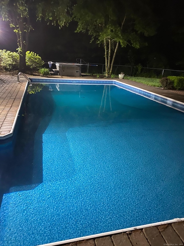 view of swimming pool featuring a hot tub