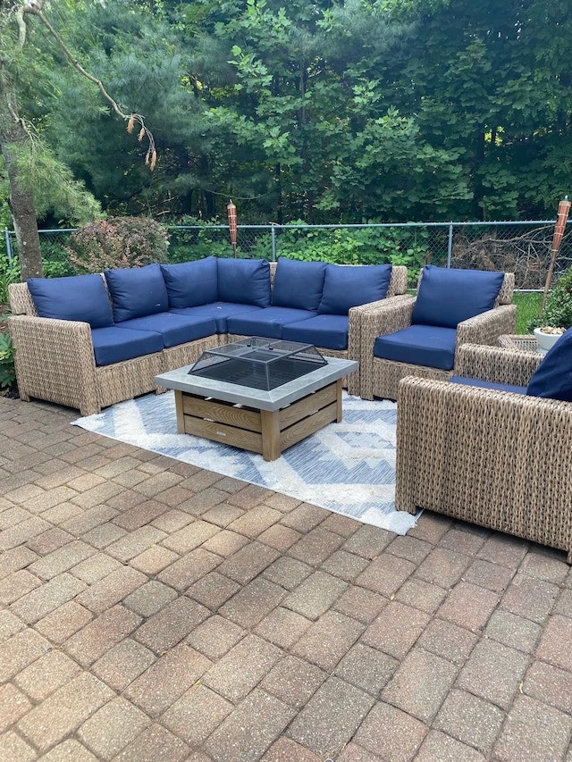 view of patio with an outdoor living space with a fire pit