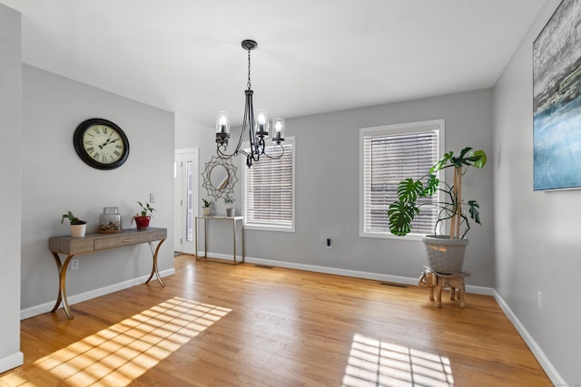 dining area with an inviting chandelier and light hardwood / wood-style floors