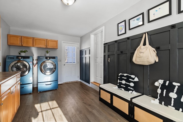 clothes washing area featuring cabinets, dark hardwood / wood-style floors, and washer and clothes dryer