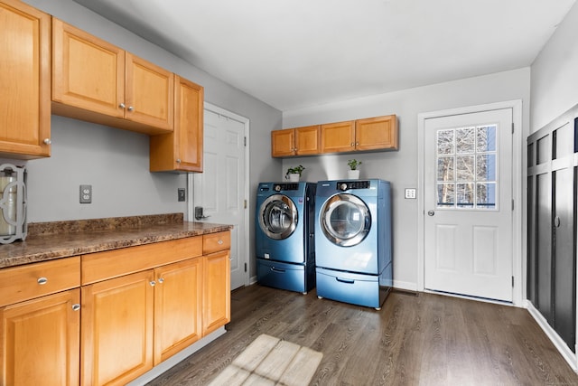 washroom featuring dark wood-type flooring, cabinets, and washing machine and clothes dryer