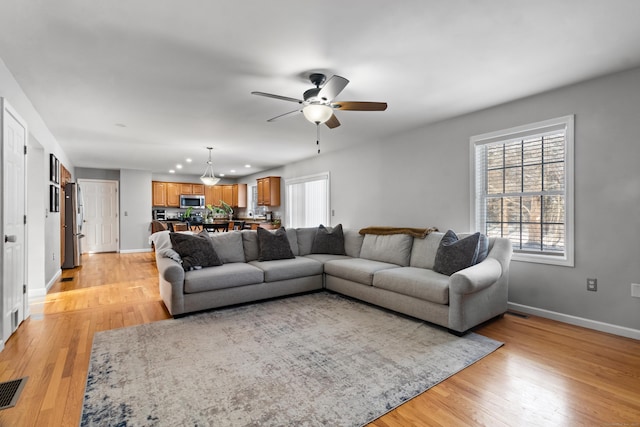 living room featuring ceiling fan and light wood-type flooring