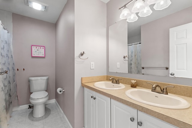 bathroom with vanity, toilet, and tile patterned floors