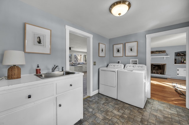 clothes washing area featuring cabinets, sink, and washer and dryer