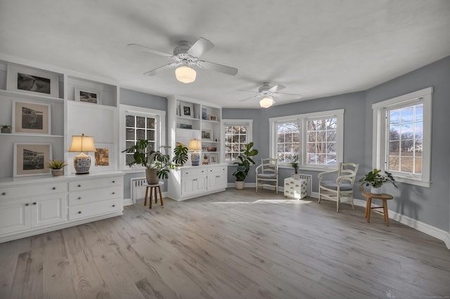 unfurnished room featuring radiator, ceiling fan, and light wood-type flooring