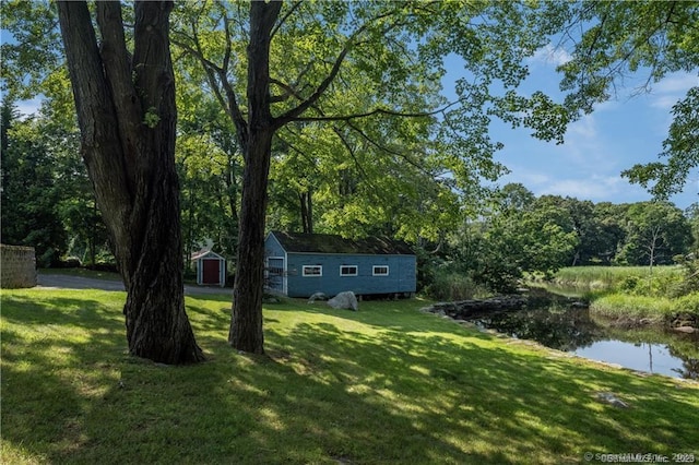 view of yard with a water view and a storage unit