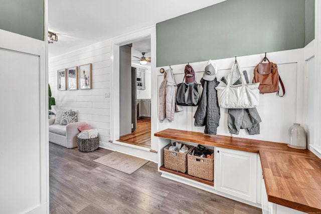 mudroom with wooden walls, hardwood / wood-style floors, and ceiling fan