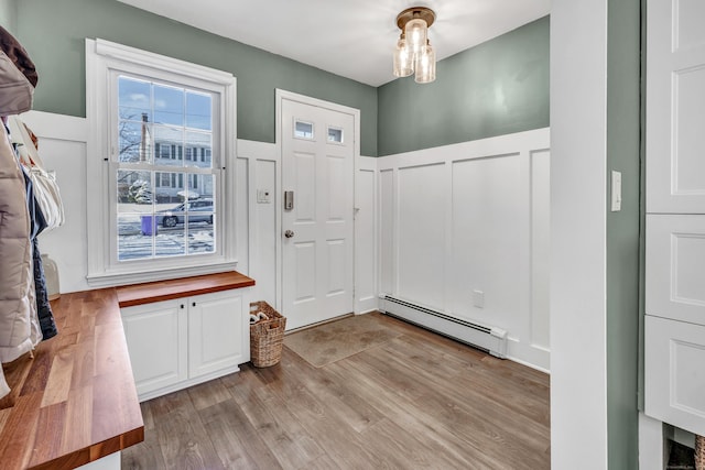 foyer entrance featuring a baseboard radiator and light hardwood / wood-style floors