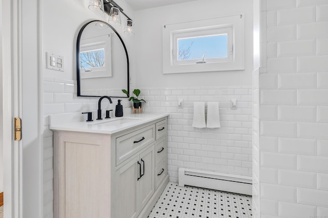 bathroom featuring a baseboard radiator, tile walls, and vanity