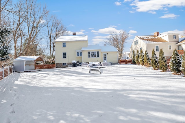 snow covered rear of property with a carport