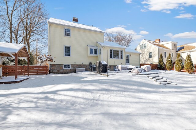 view of snow covered rear of property