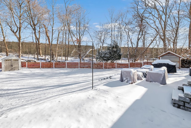 yard layered in snow with a storage shed