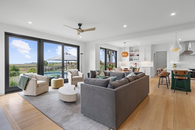 living room featuring ceiling fan and light hardwood / wood-style floors