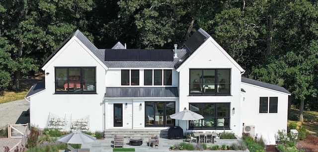 rear view of house featuring ac unit, a patio area, and solar panels