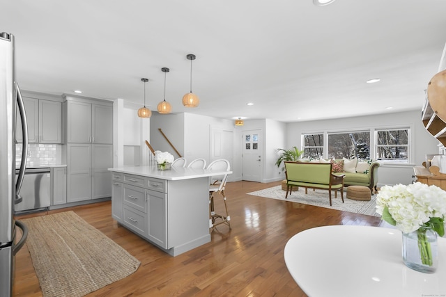 kitchen with pendant lighting, gray cabinets, a center island, and a breakfast bar