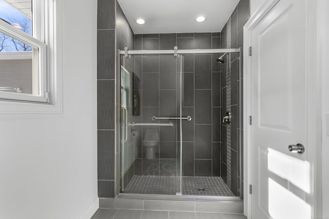 bathroom featuring walk in shower, tile patterned floors, and toilet