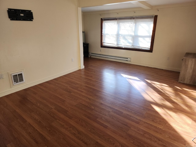 spare room featuring baseboard heating and hardwood / wood-style floors