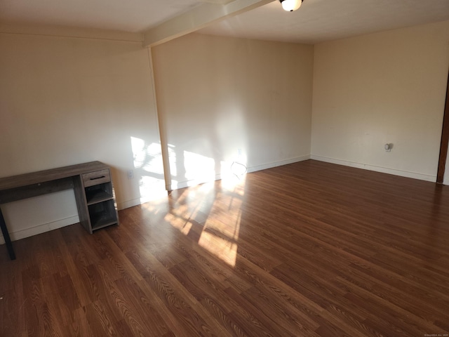 spare room with dark hardwood / wood-style floors and beamed ceiling