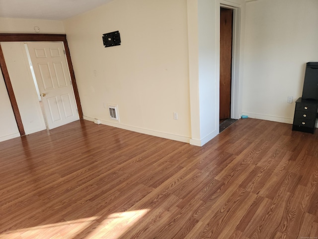 unfurnished room with dark hardwood / wood-style flooring